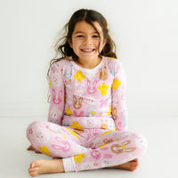 Child sitting wearing Pink Pastel Parade two piece pajama set