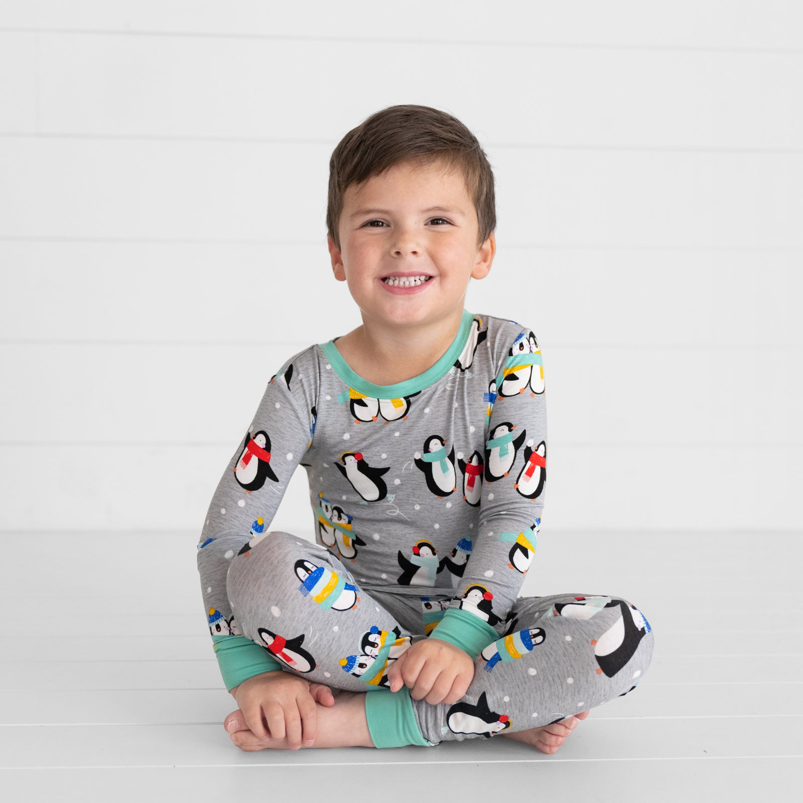 Child sitting wearing Penguin Party two piece pj set