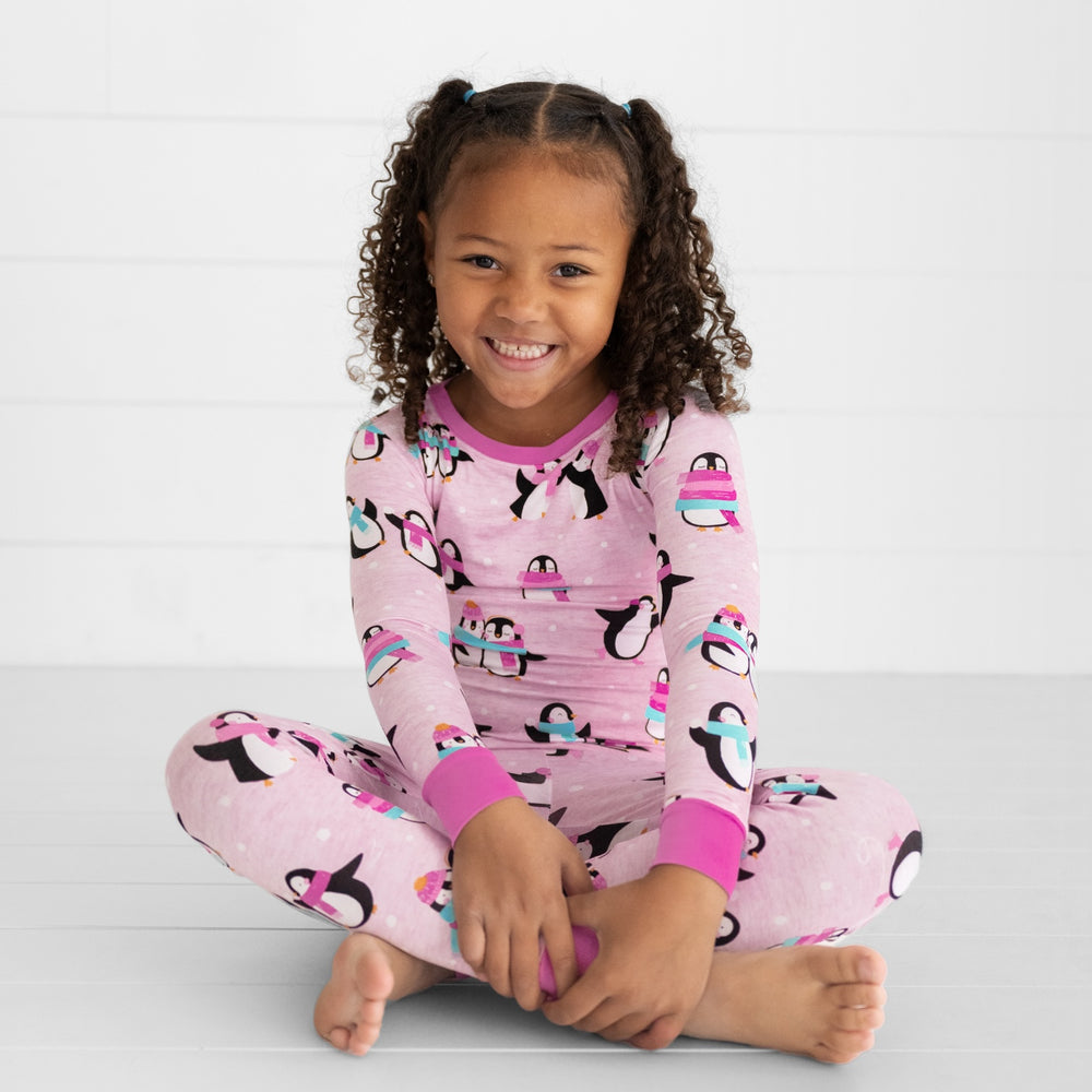 child sitting wearing pink Penguin Party two piece pajama set