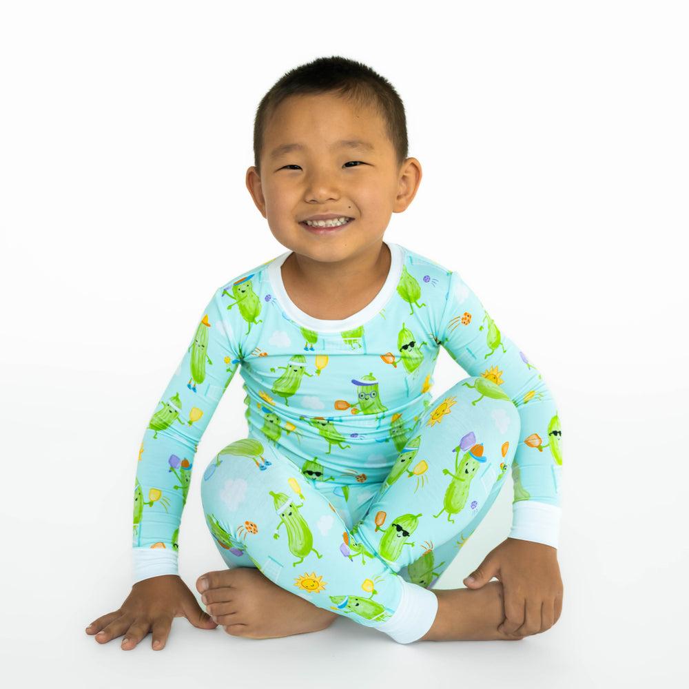 Boy sitting while wearing the Pickle Power Two-Piece Pajama Set
