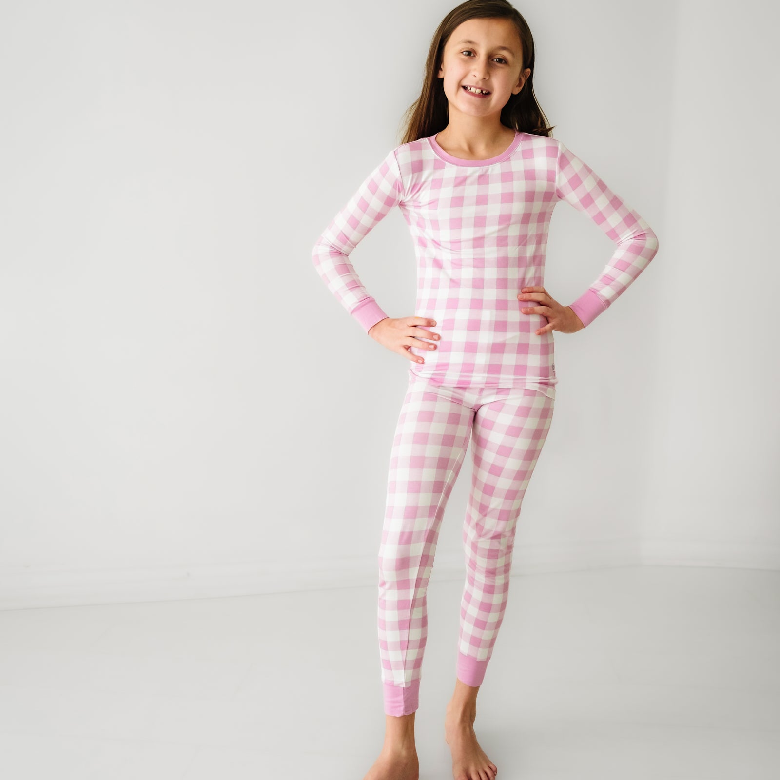 Child posing wearing a Pink Gingham two piece pajama set
