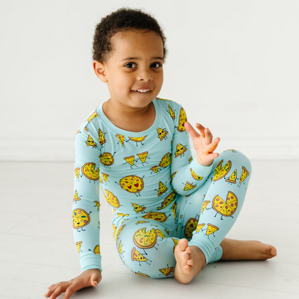 Child sitting wearing a Pizza Pals two piece pajama set