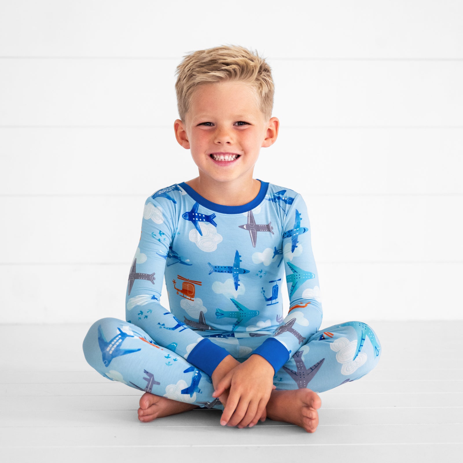 child sitting wearing a Let's Fly two piece pj set