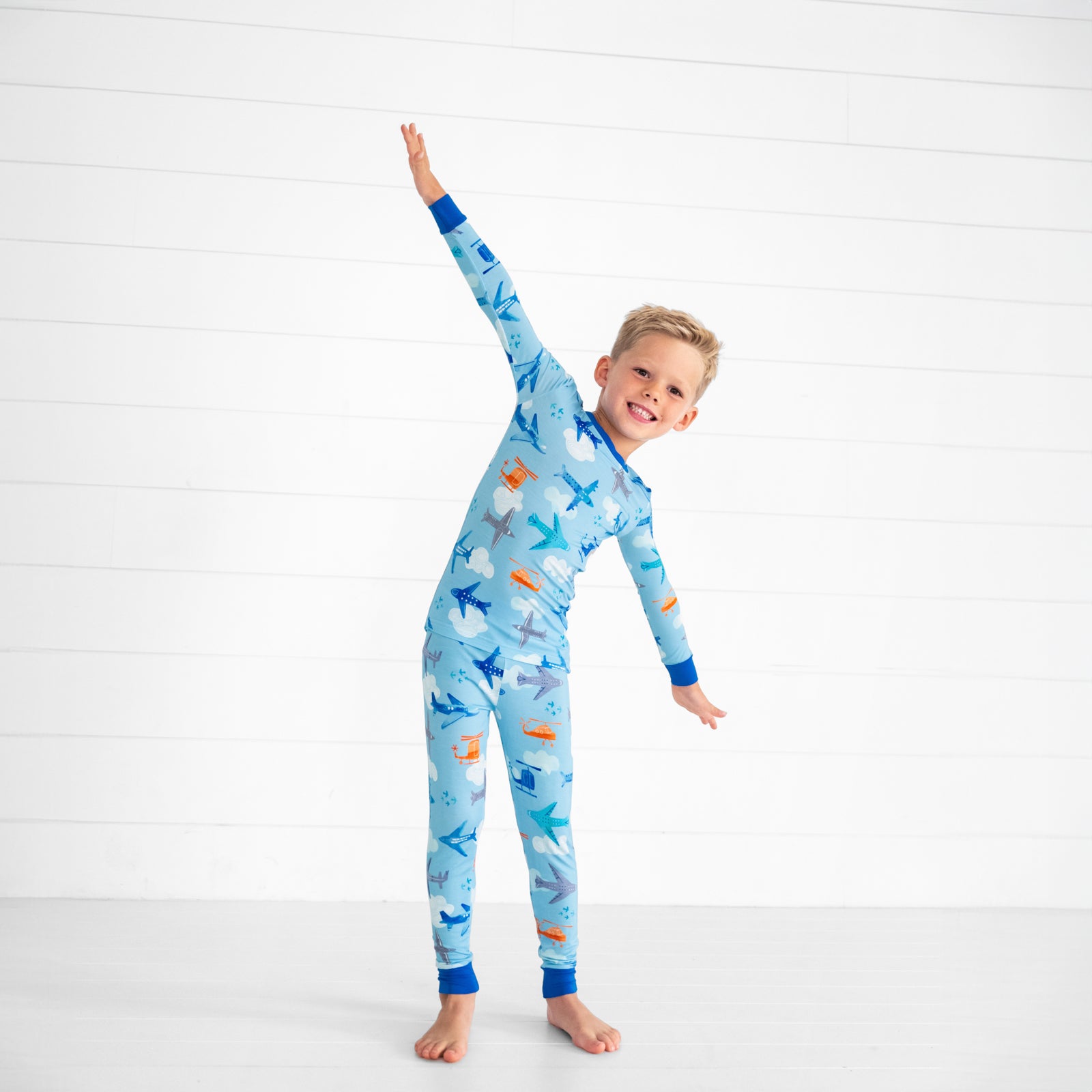 Child posing wearing a Let's Fly two piece pj set