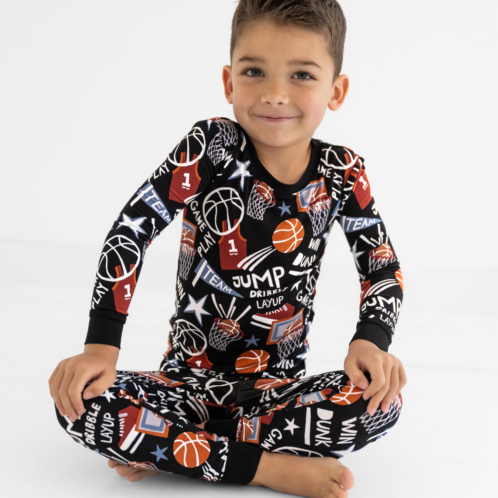 Sitting child wearing the Black Slam Dunk bamboo kids pajama set