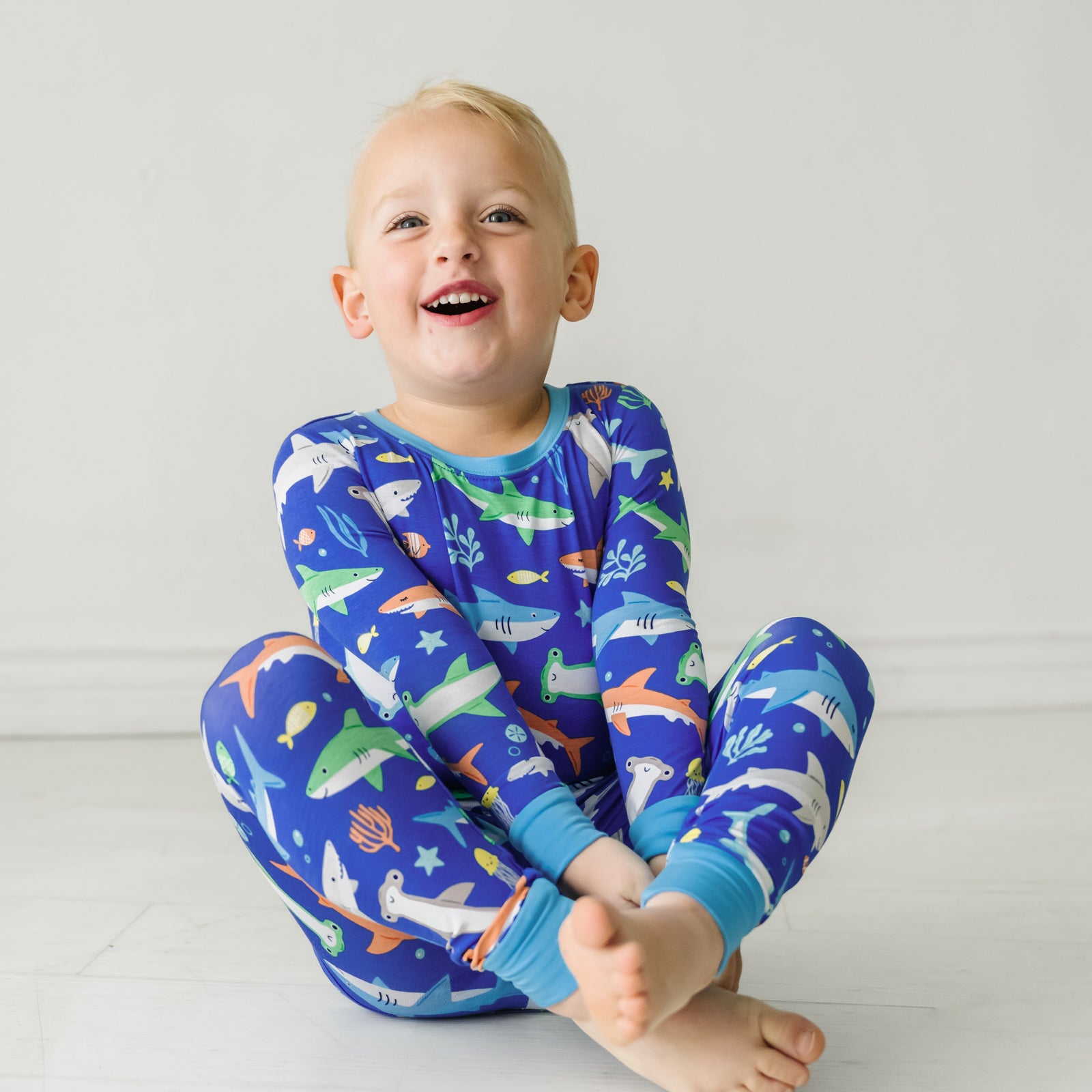 Child sitting on the ground wearing a Rad Reef two-piece pajama set
