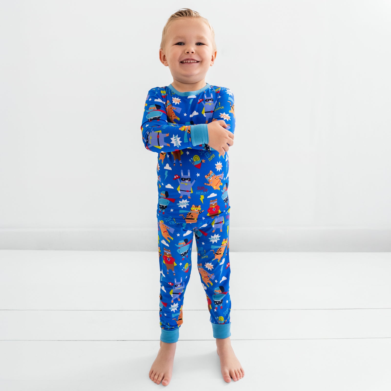 Child standing wearing the Blue Sleepy Heroes Two-Piece PJ Set