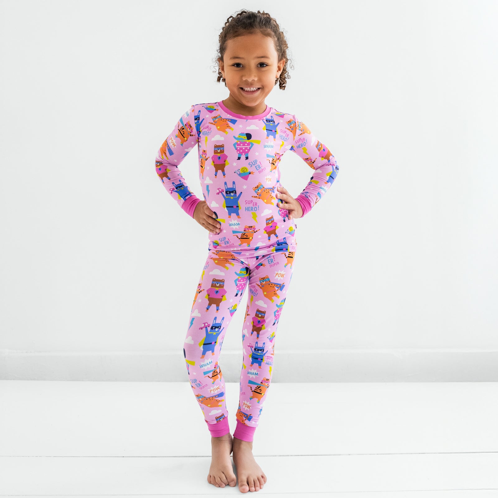 Child standing in the Pink Sleepy Heroes Two-Piece Long Sleeve & Pants Pajama Set