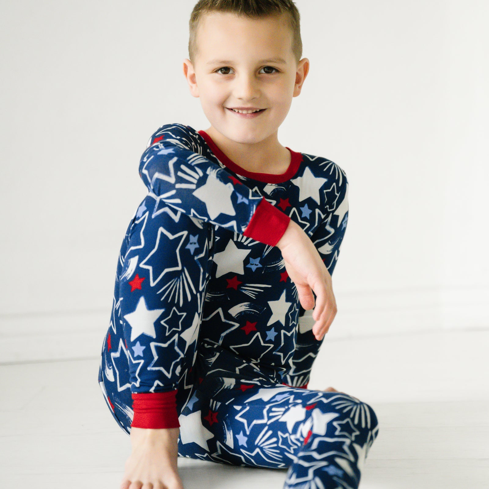 Alternate image of a child sitting wearing a Star Spangled two piece pajama set