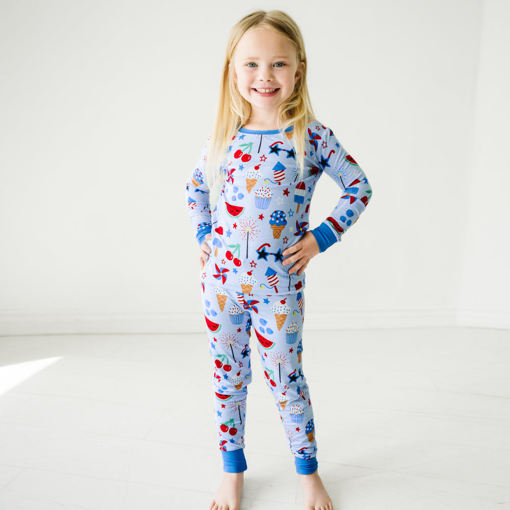 Child posing wearing a Stars, Stripes, and Sweets two piece pajama set