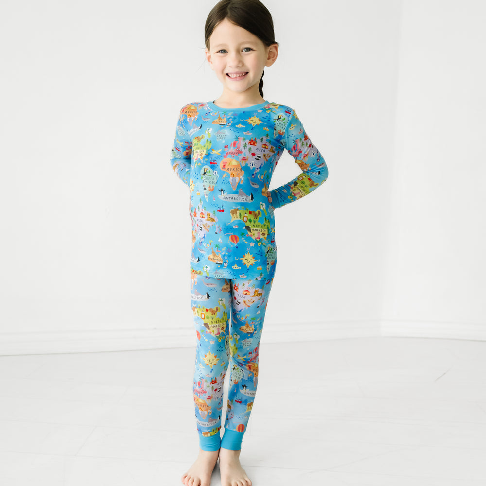 Child posing wearing an Around the World two piece pajama set