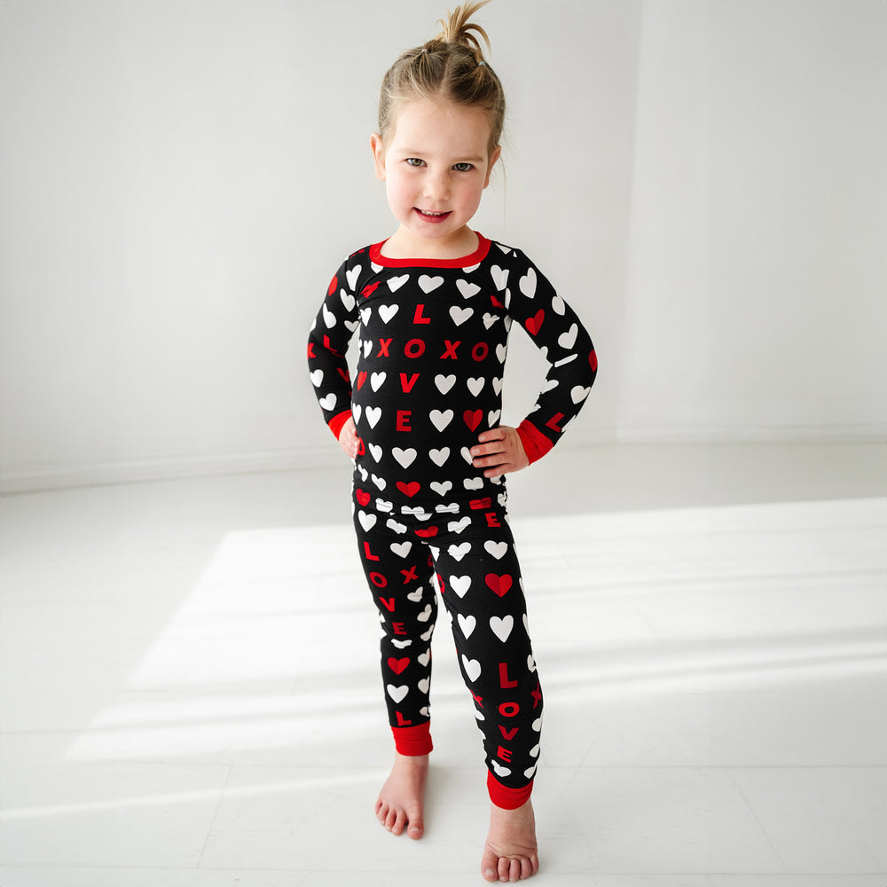 Click to see full screen - Child posing wearing Black XOXO two piece pajama set