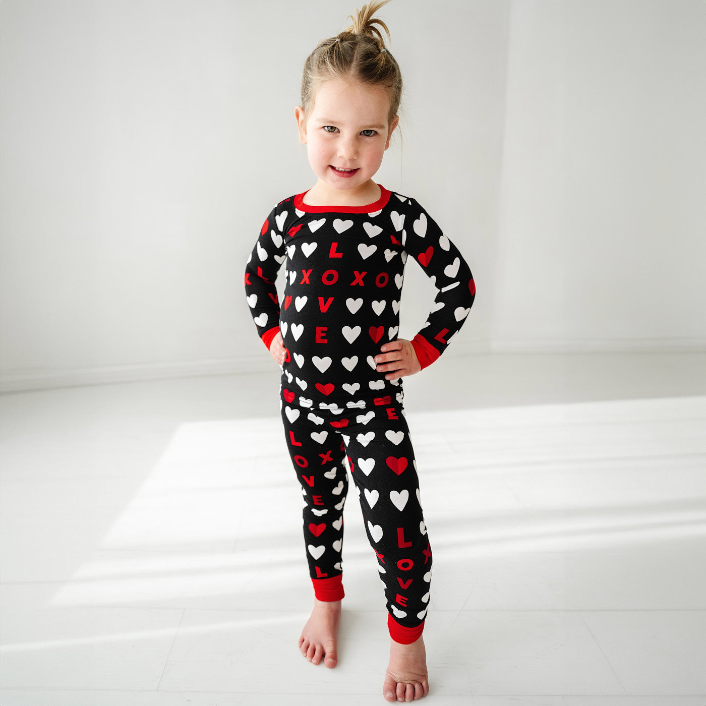 Child posing wearing Black XOXO two piece pajama set