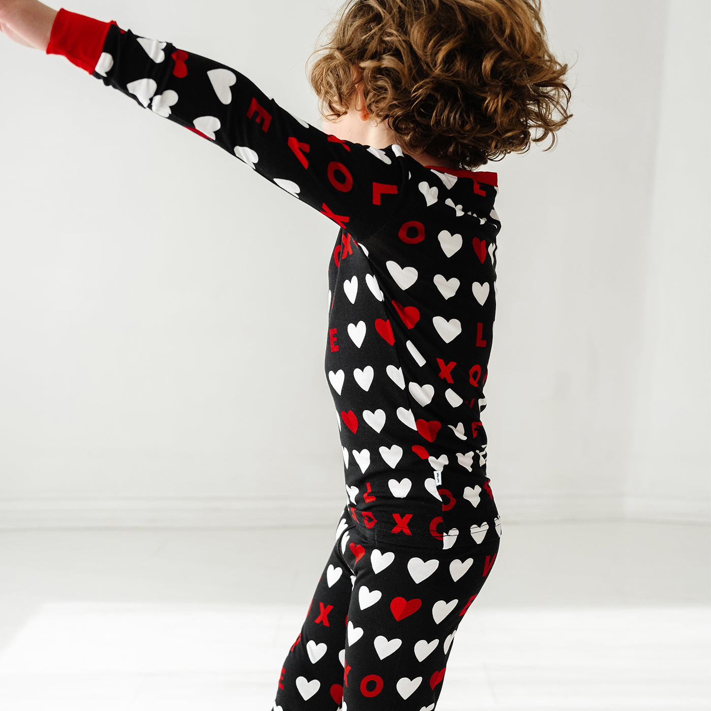 Child twirling wearing Black XOXO two piece pajama set