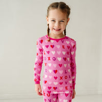 Child wearing a Pink XOXO two piece pajama set showing off the pajama top