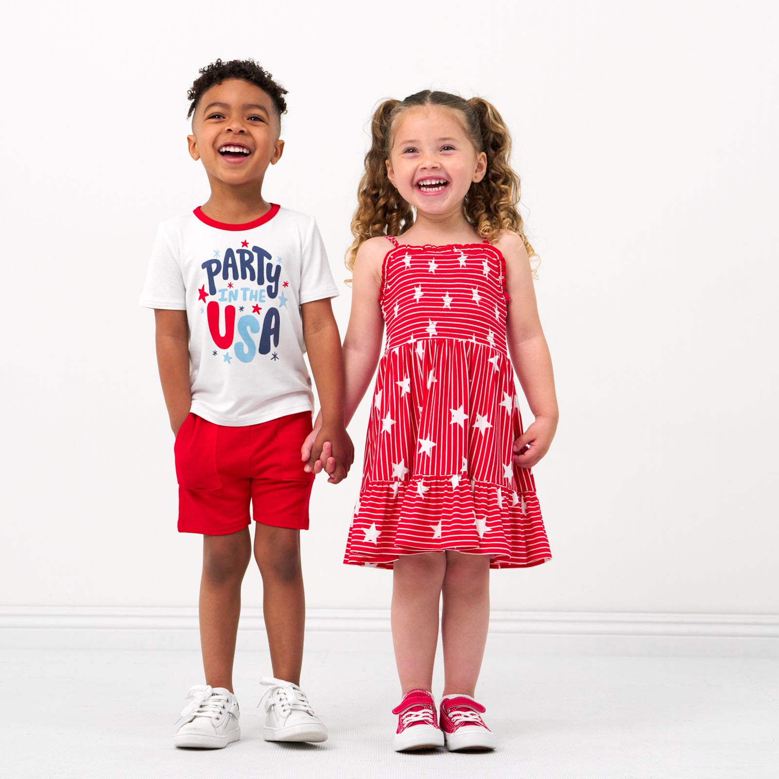 Two children holding hands wearing coordinating 4th of July Play outfits