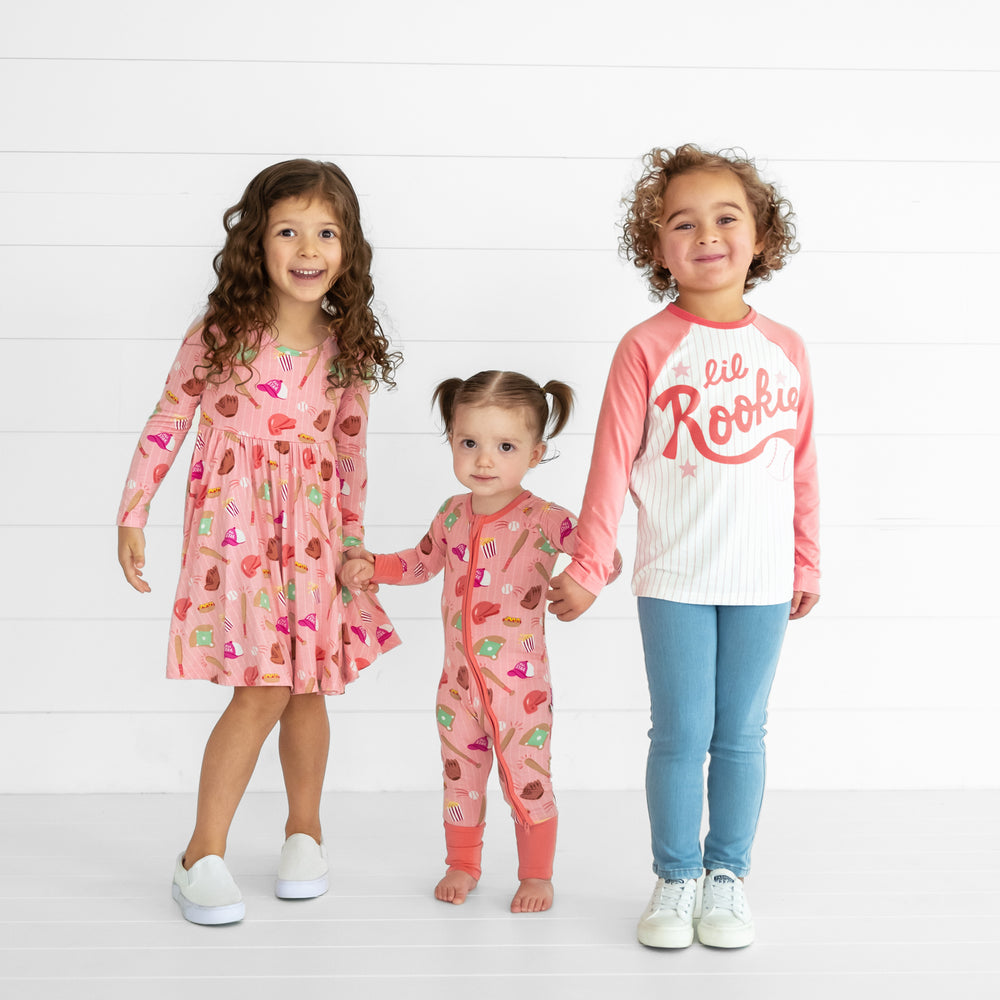 Three children wearing matching Pink All Stars Play styles and pajamas