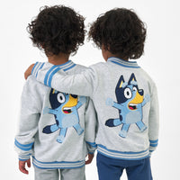 Image of two children wearing the Bluey Gray Bomber Jacket showing the back view detail