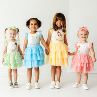 Four children wearing coordinating Disney Princess flutter tiered tutu dresses