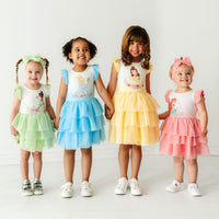 Four children wearing coordinating Disney Princess flutter tiered tutu dresses