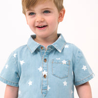 Close up image of a child wearing a Denim Stars polo shorty romper