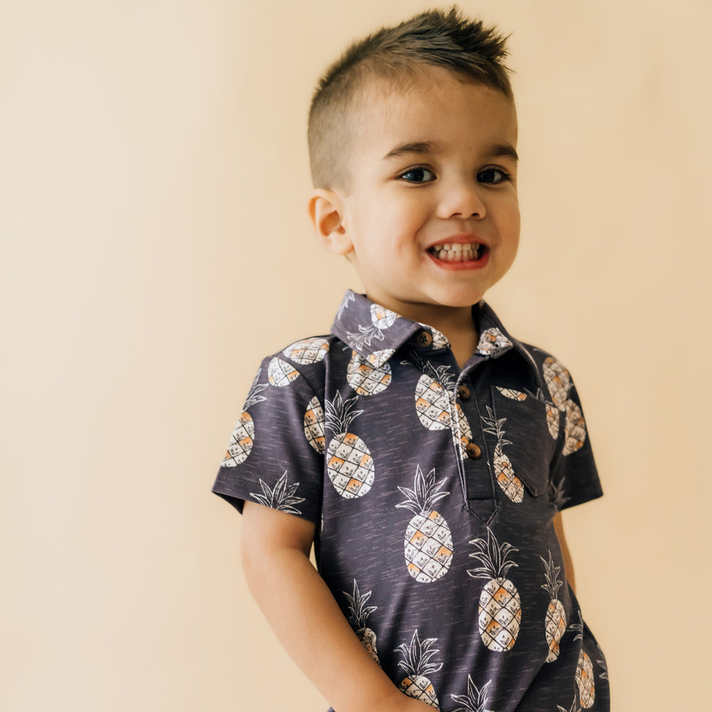 Close up image of a child wearing Sweet Paradise polo shorty romper