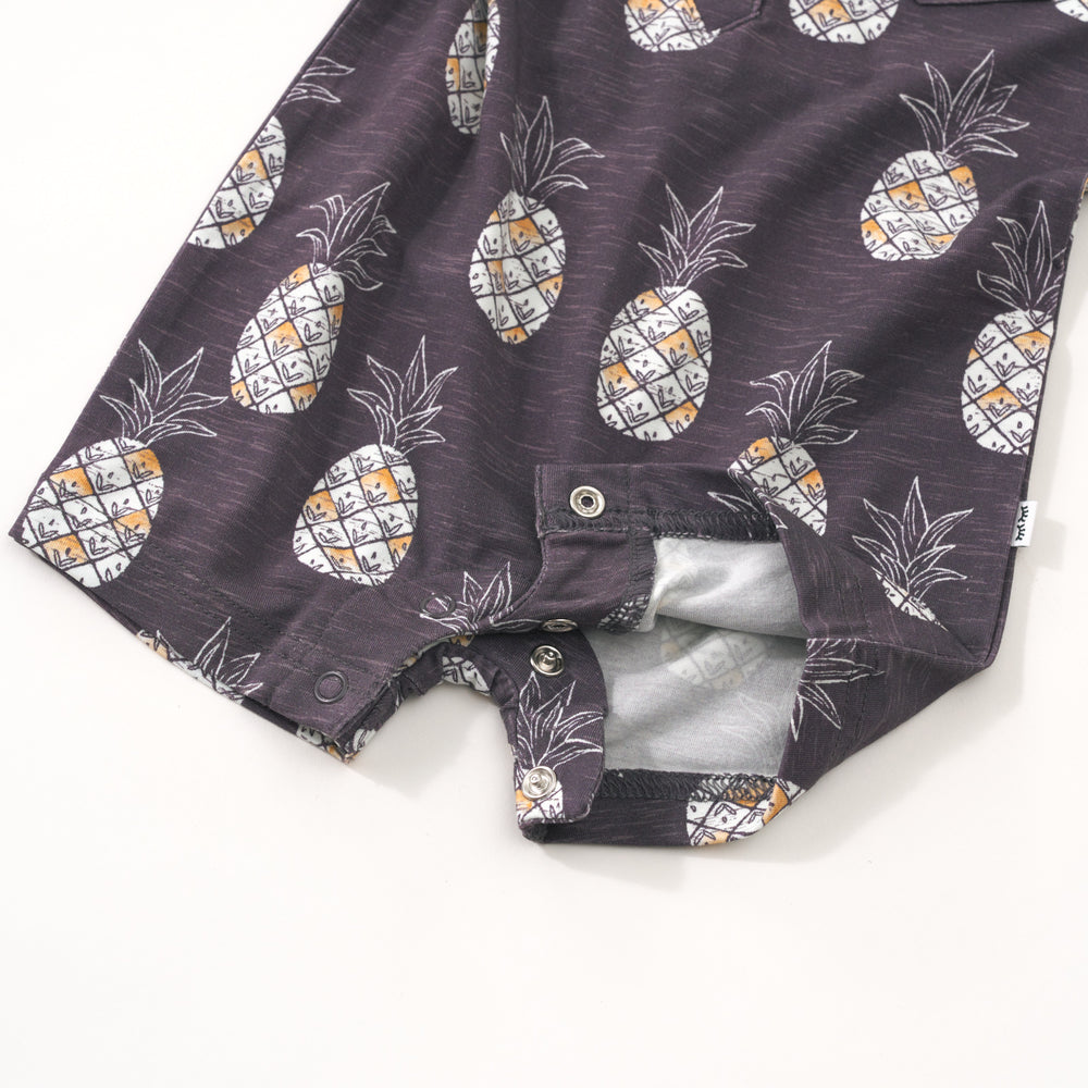 Flat lay image showing the snaps on the Sweet Paradise polo shorty romper