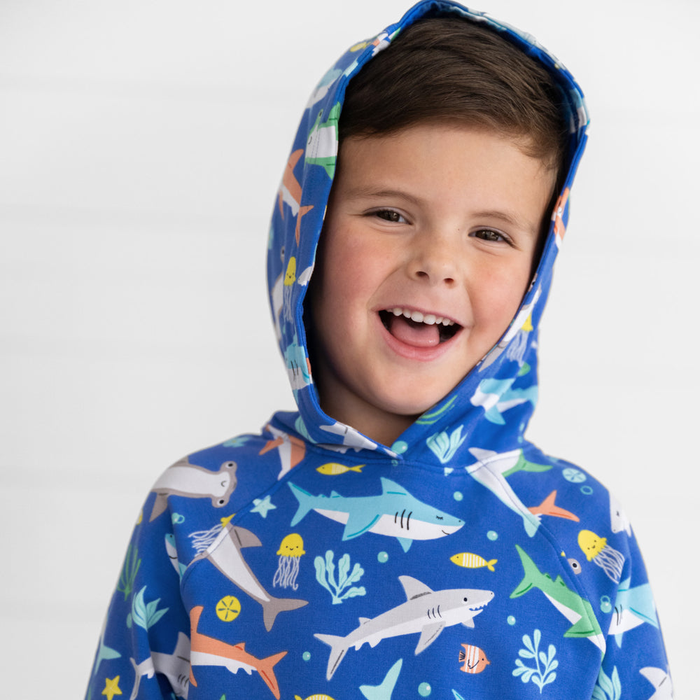 Close up image of boy smiling and wearing the hoodie up on the Rad Reef Pullover Hoodie