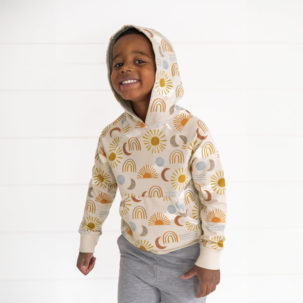 Image of a child wearing a Desert Sunrise Pullover Hoodie with the hood up and Heather Gray Jogger 