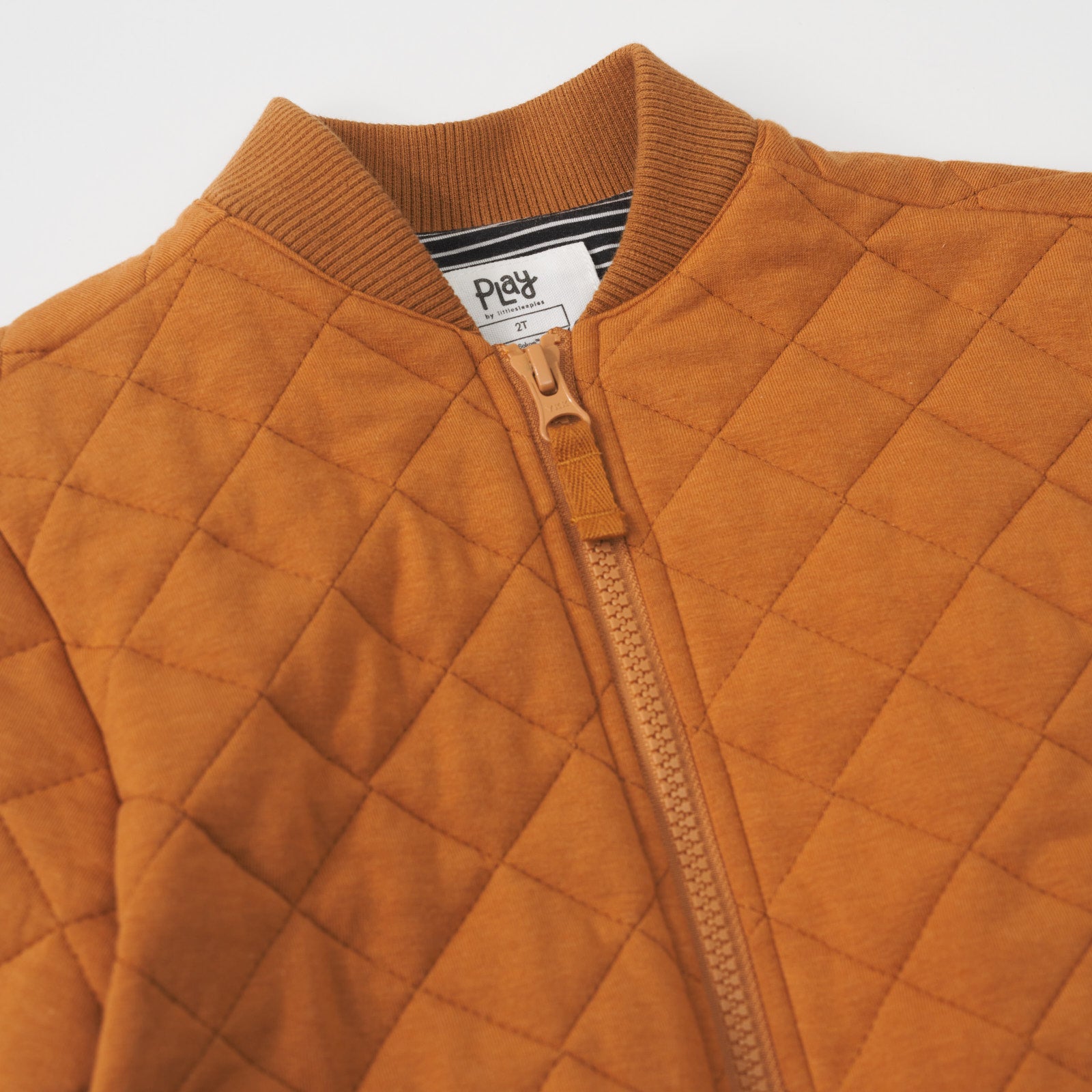 Close-up view of the quilted design and chunky zipper on a Golden Brown quilted varsity jacket