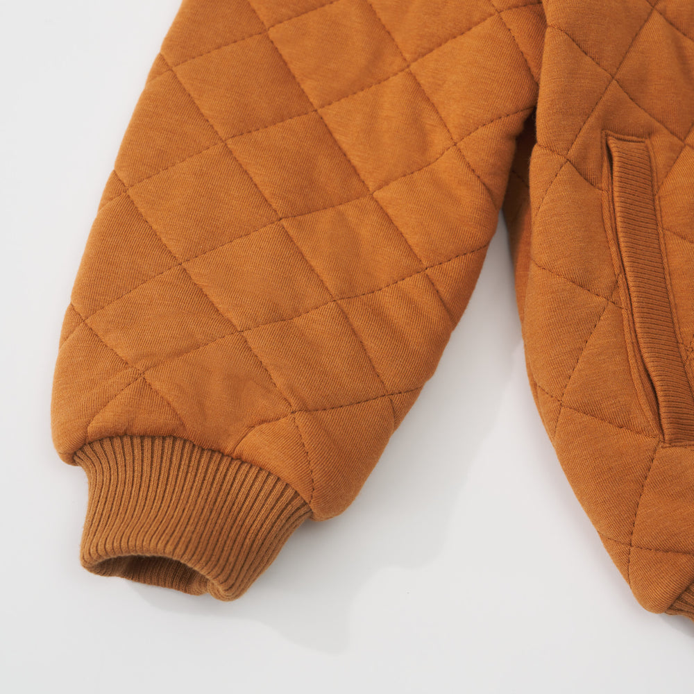 Close-up view of the sleeve cuff and pocket on a Golden Brown quilted varsity jacket