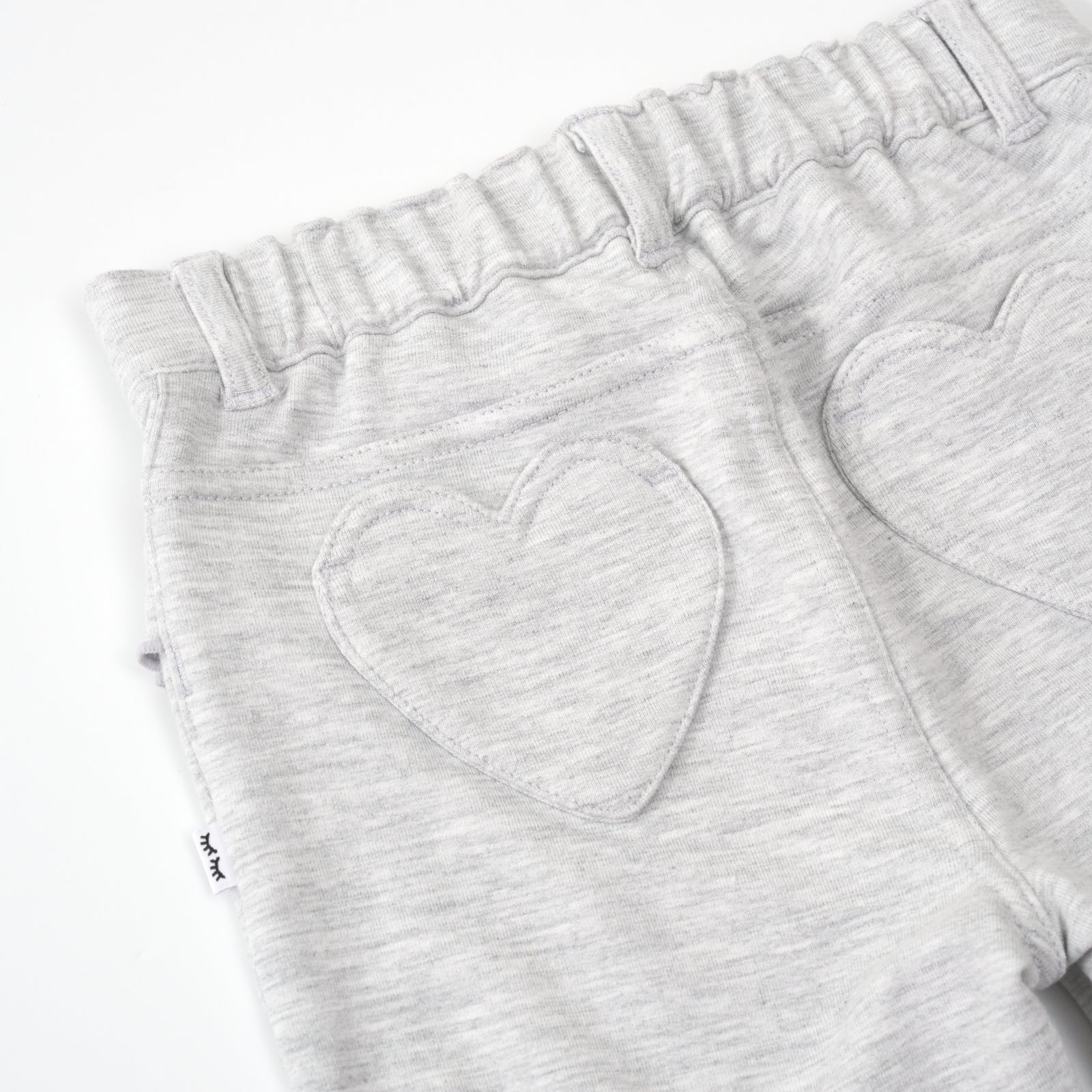 close up view of the heart pockets on a light heather gray ruffle heart pocket pant