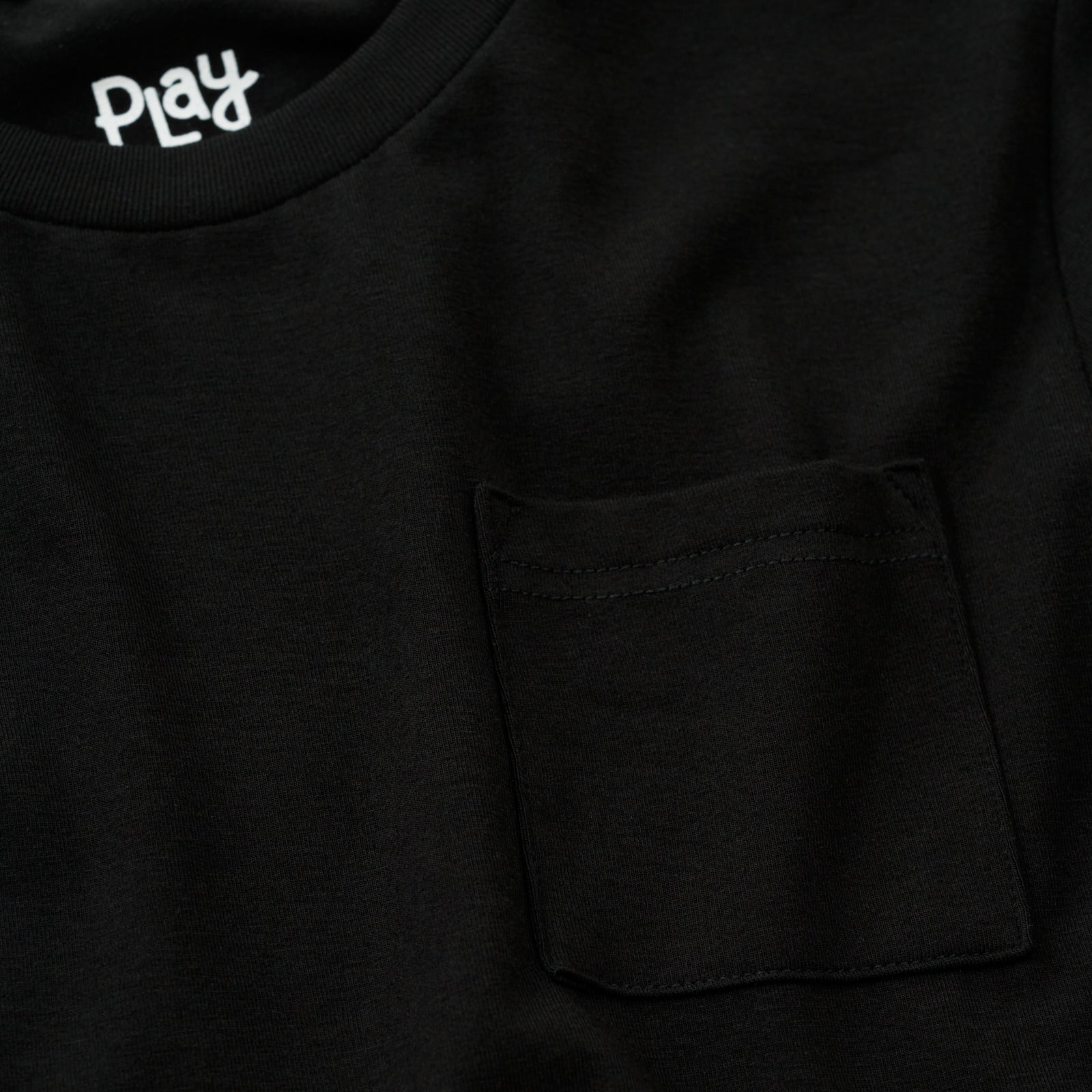Close up image of the pocket and collar detail on the Black Short Sleeve Relaxed Pocket Tee
