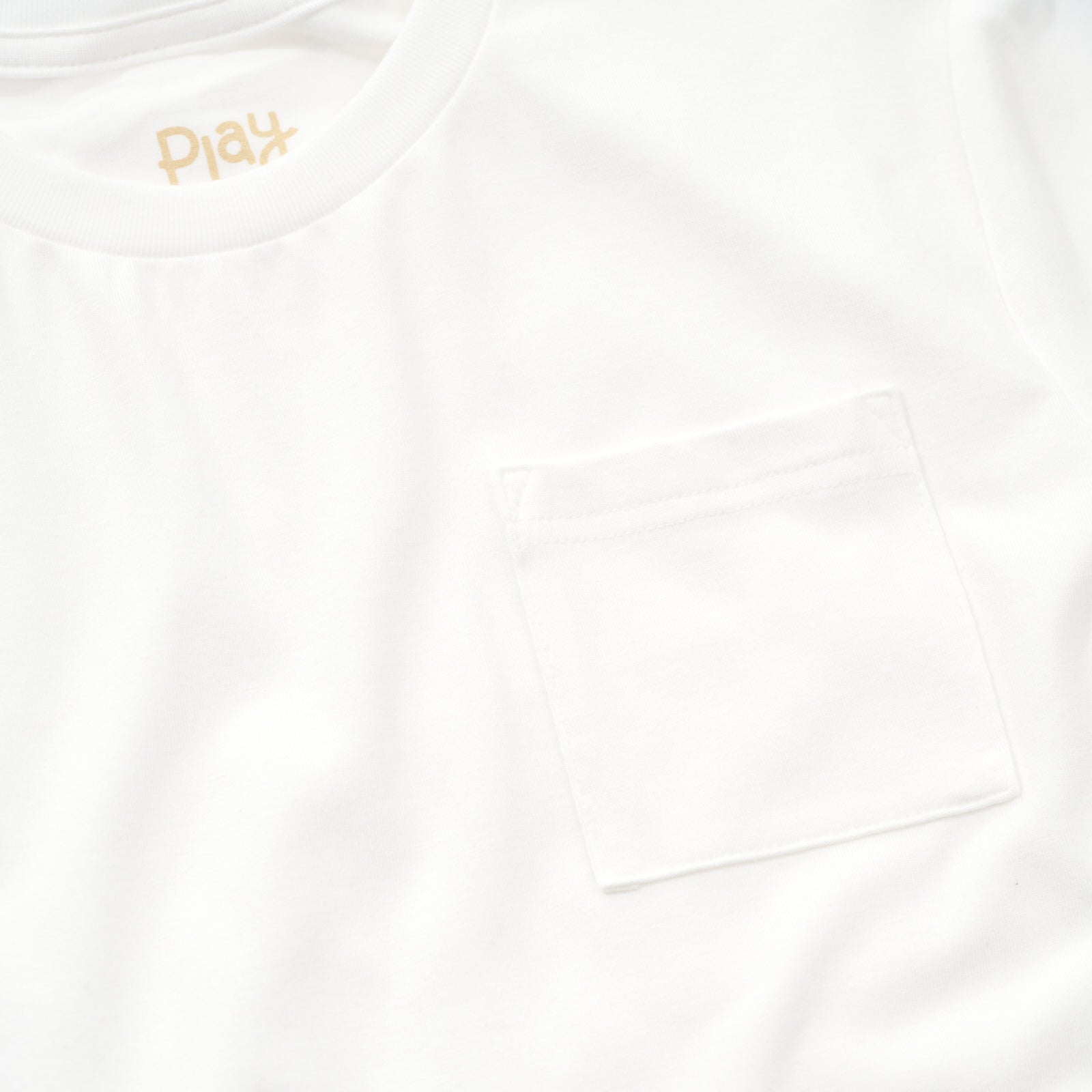 Close up detailed image of the pocket on a Soft White short Sleeve relaxed pocket tee
