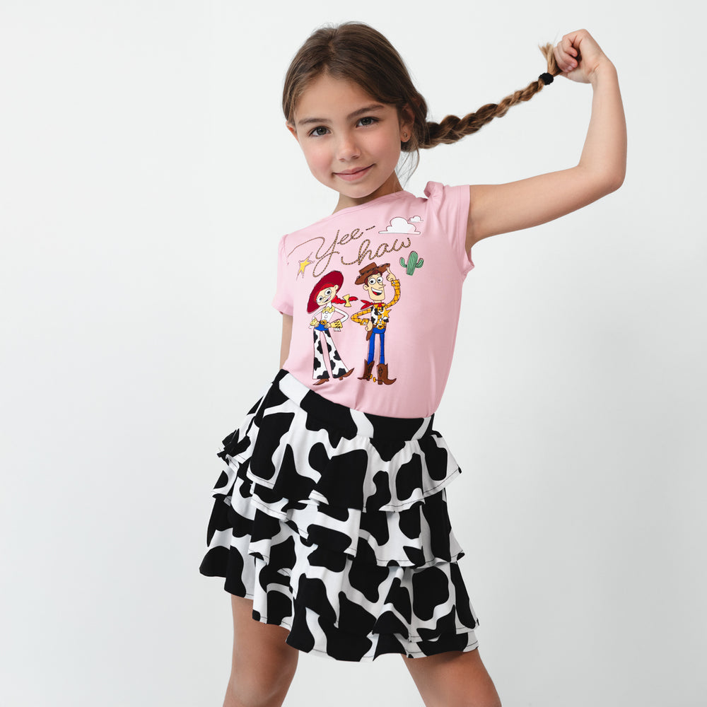 Child wearing a Moo Crew Ruffle Skort and Disney & Pixar Jessie & Woody Puff Sleeve Tee