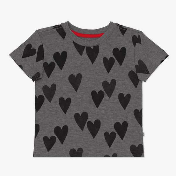 Flat lay of a Heather Hearts Relaxed Tee featuring short sleeves and black hearts on a dark heather gray background