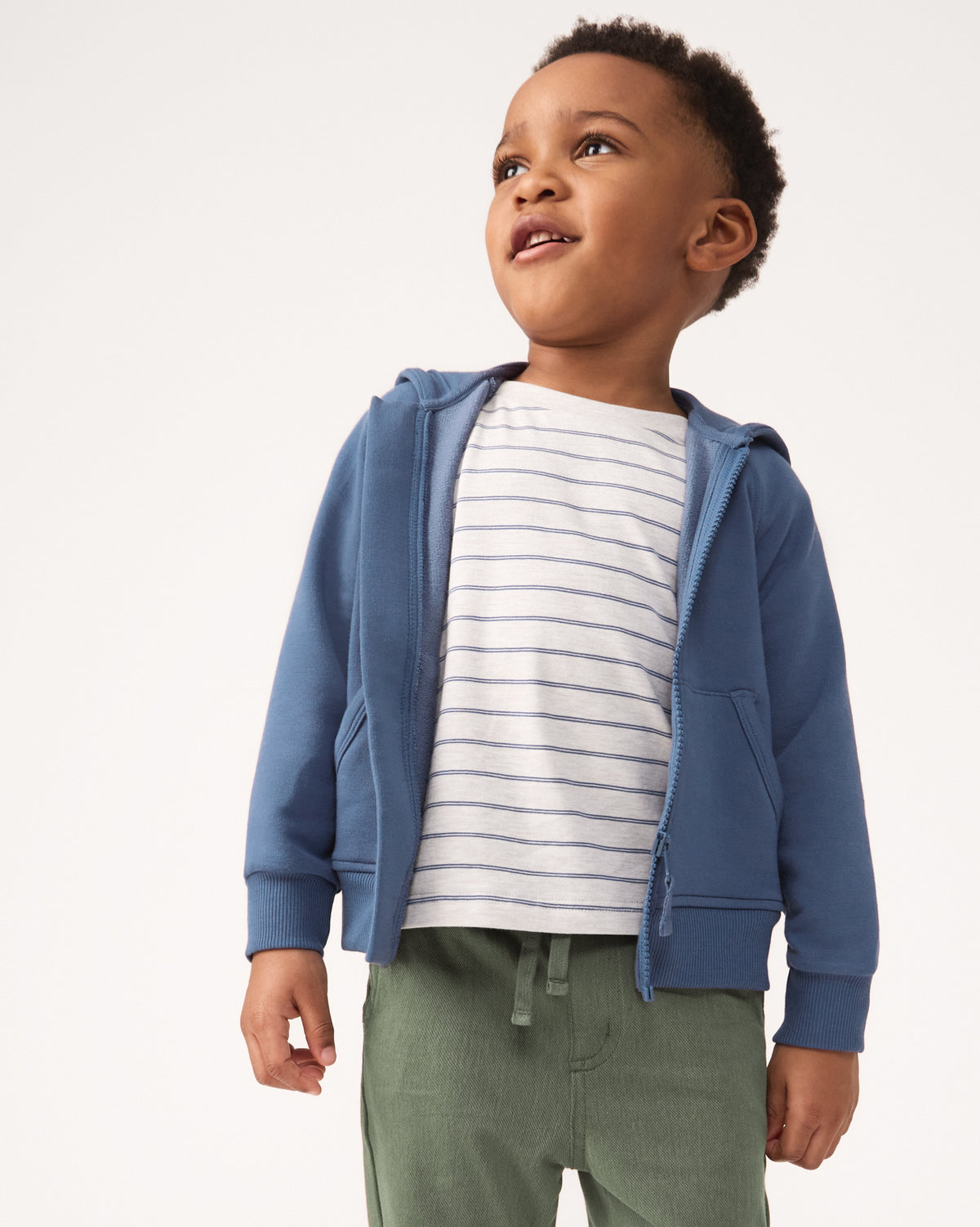 Boy wearing the Stone Stripes Short Sleeve Relaxed Tee with a navy hoodie and green bottoms