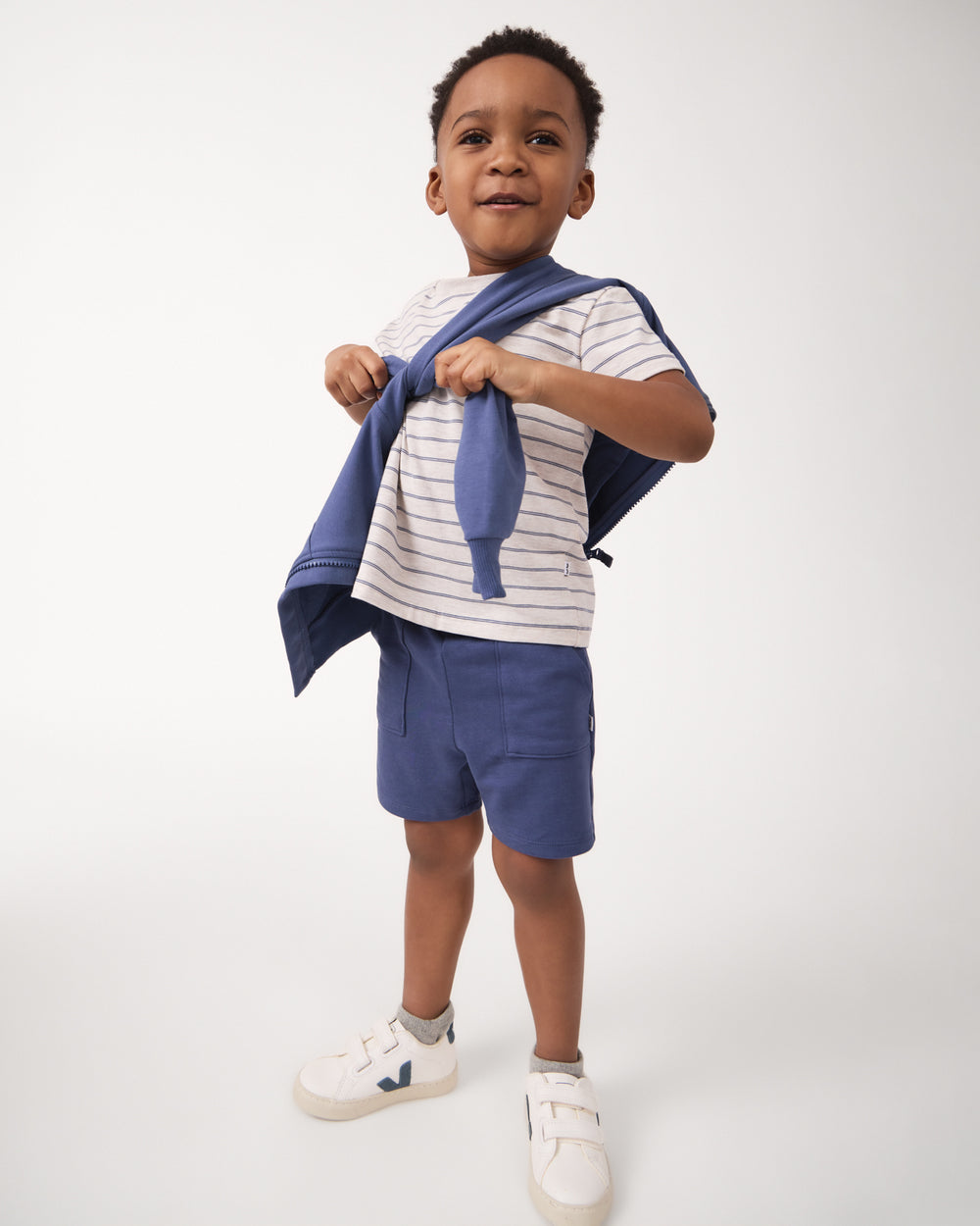 Boy wearing the Vintage Navy Shorts with Veja sneakers