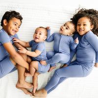 Four children cuddling together wearing Slate Blue pajamas in two piece and zippy styles