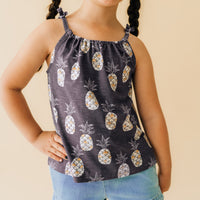 Close up image of a child wearing a Sweet Paradise flowy bow strap tank