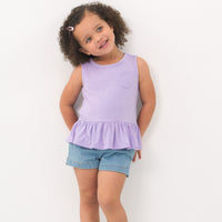 Child wearing a Pastel Lilac peplum pocket tank and coordinating Play shorts