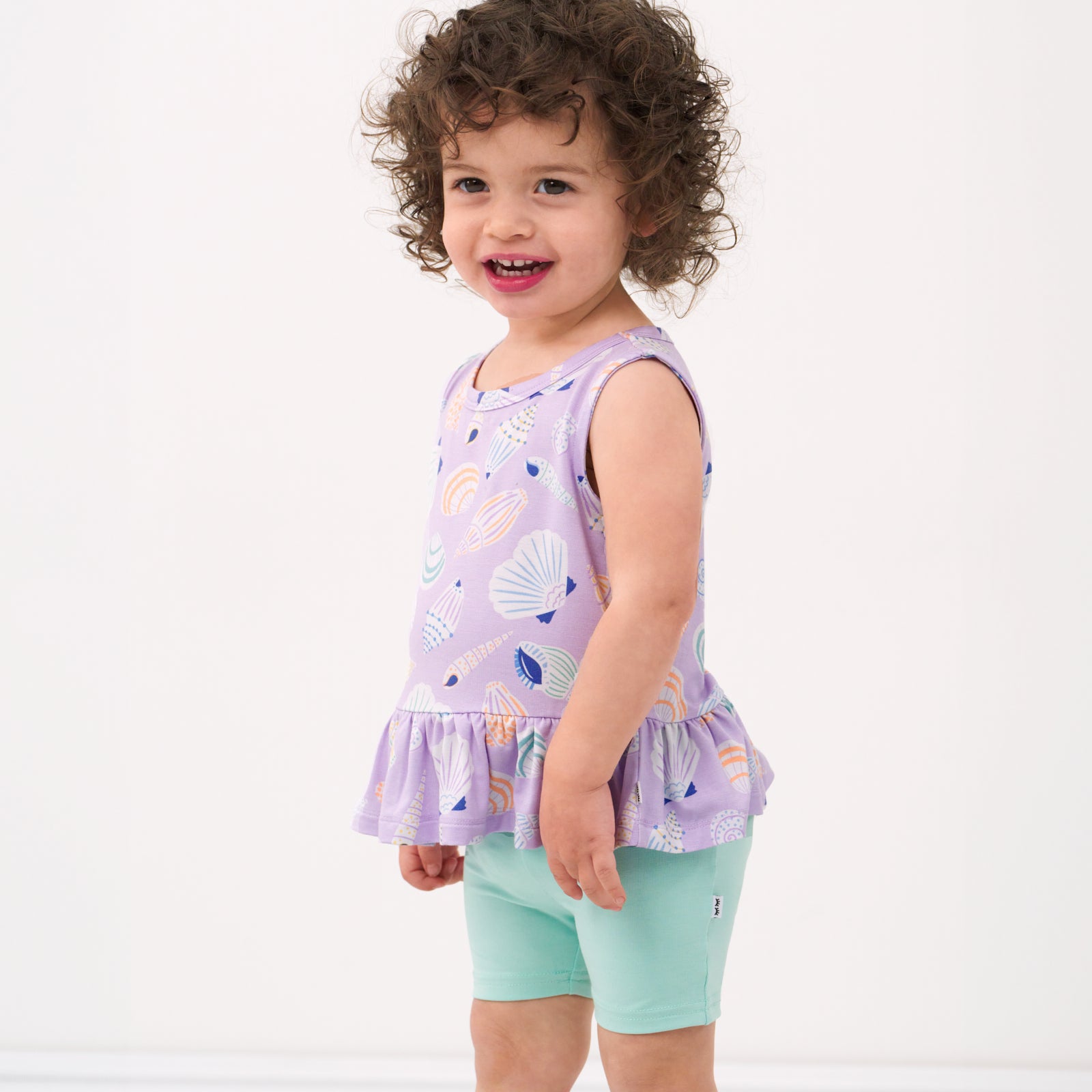 profile view of a child wearing a Sandy Treasures peplum tank