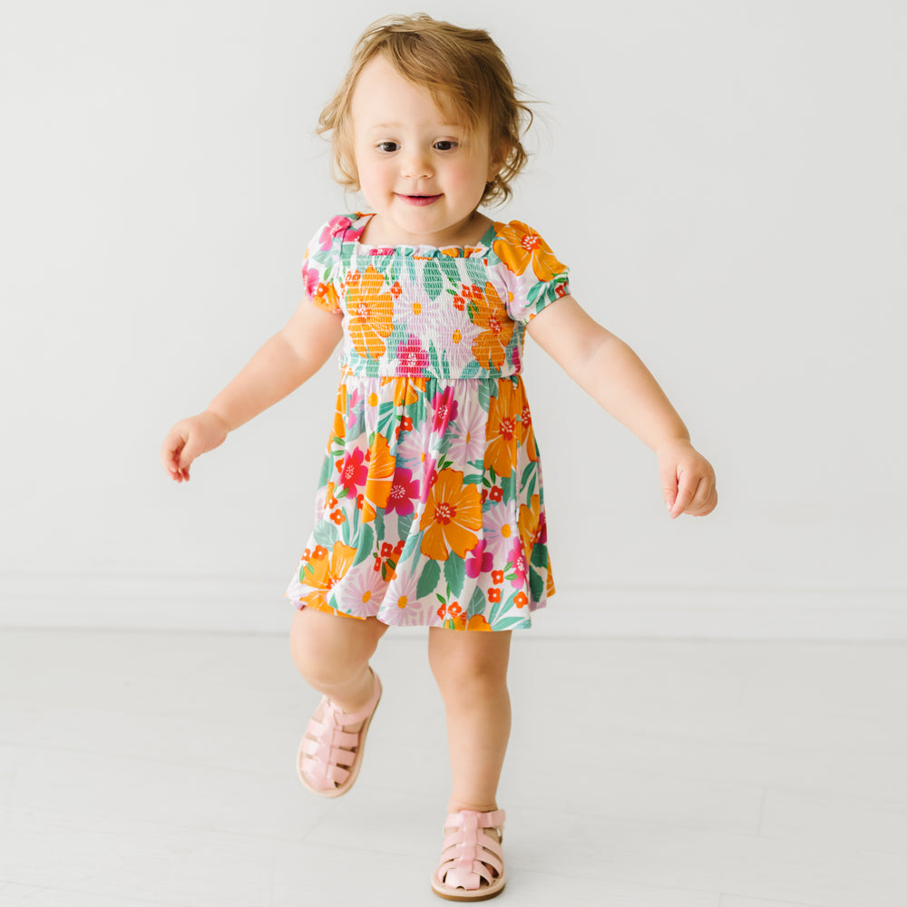 Child wearing a Beachy Blooms puff sleeve smocked dress with bloomer