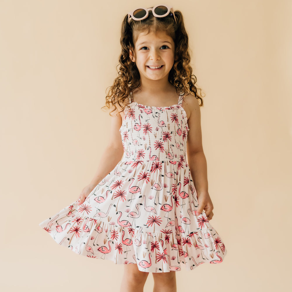 Child posing wearing a Pink Palms tank smocked dress