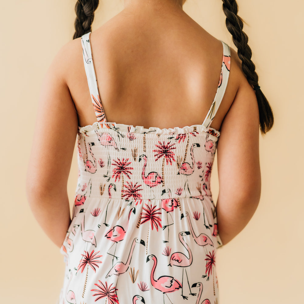 Back view of a child wearing a Pink Palms tank smocked dress with a close up on the smocked backing