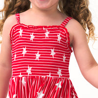 Close up image of a child wearing a Stripes & Sparkles tank smocked dress, detailing the smocked top