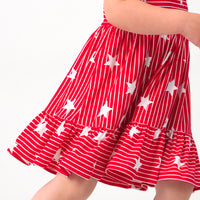 Close up image of a child wearing a Stripes & Sparkles tank smocked dress