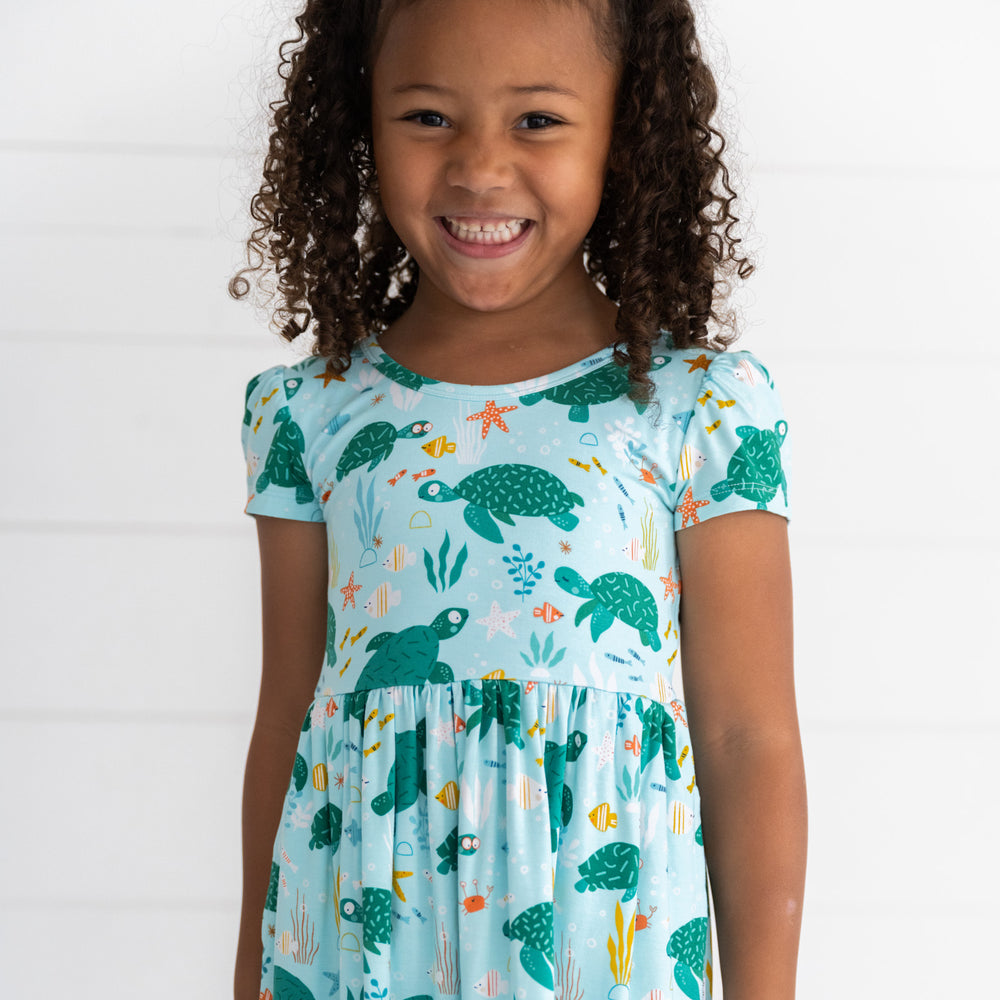 Close up image of a child wearing a Sea Turtle Friends Skater Dress