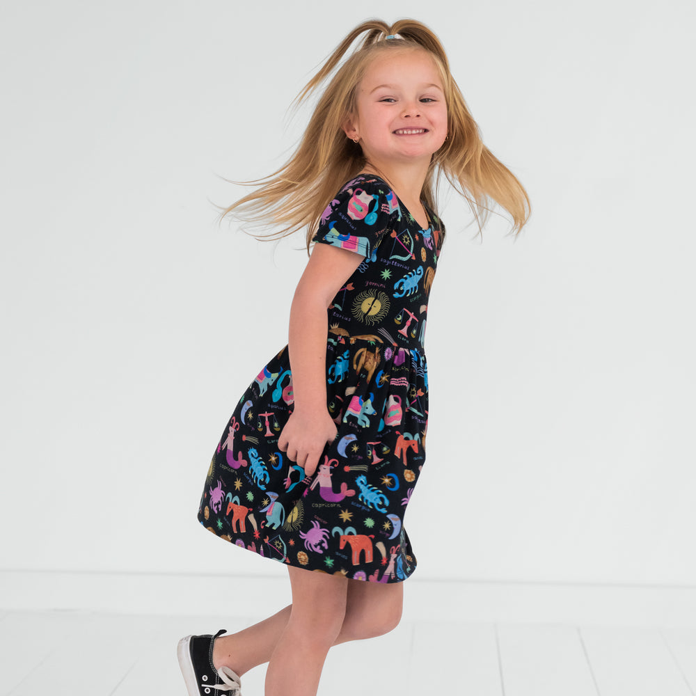 child spinning around wearing a star signs skater dress