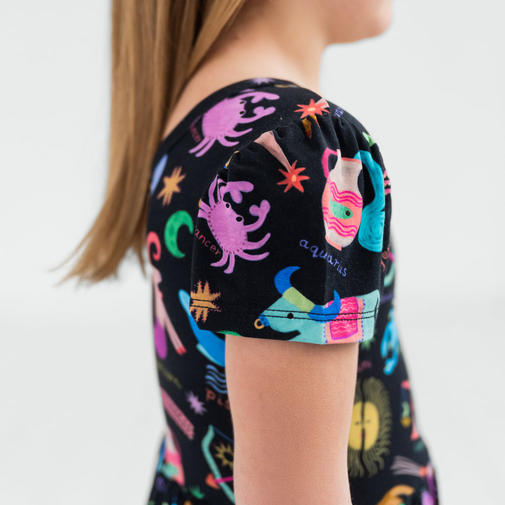 close up view of a child wearing a star signs skater dress